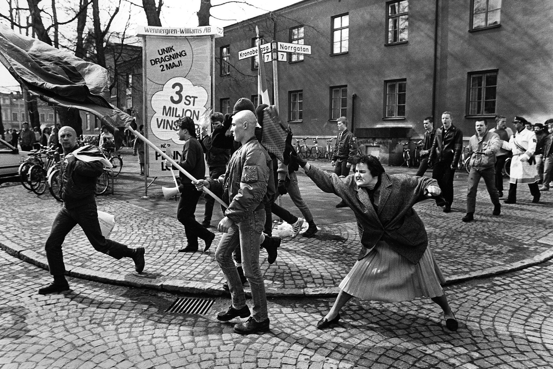 Svartvitt fotografi på Danuta Danielsson som slår en fanbärande demonstrant för Nordiska rikspartiet (NRP) med sin handväska taget av Pressfotografen Hans Runesson på Dagens Nyheter