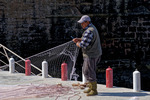 En av fiskarna rensar sina nät nere vid Citadellet