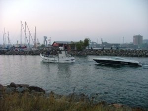 122 fiskebåt som bogserar racerbåt förbi sailor.jpg